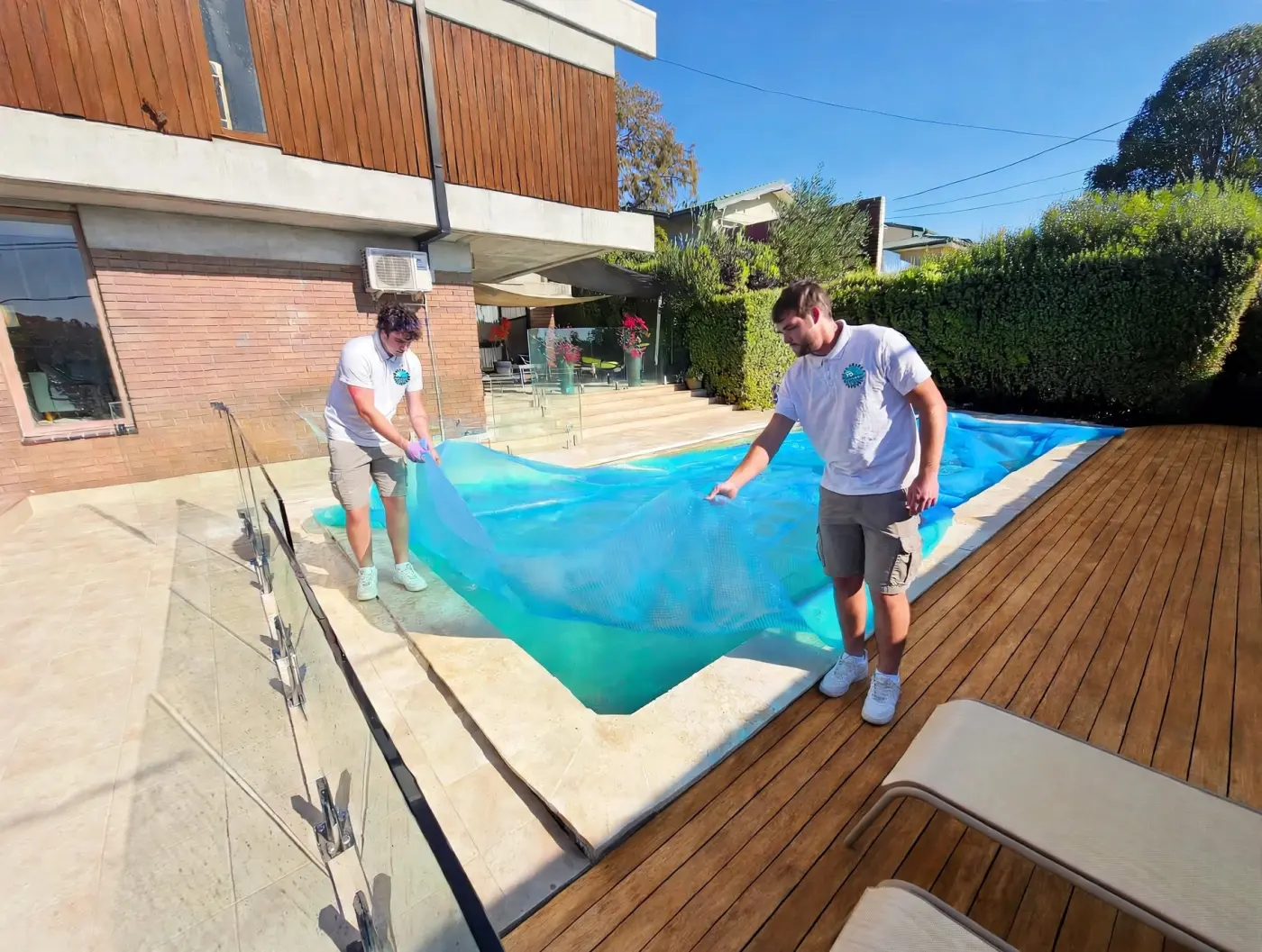 PoolSmart technicians fitting a solar cover to a backyard pool